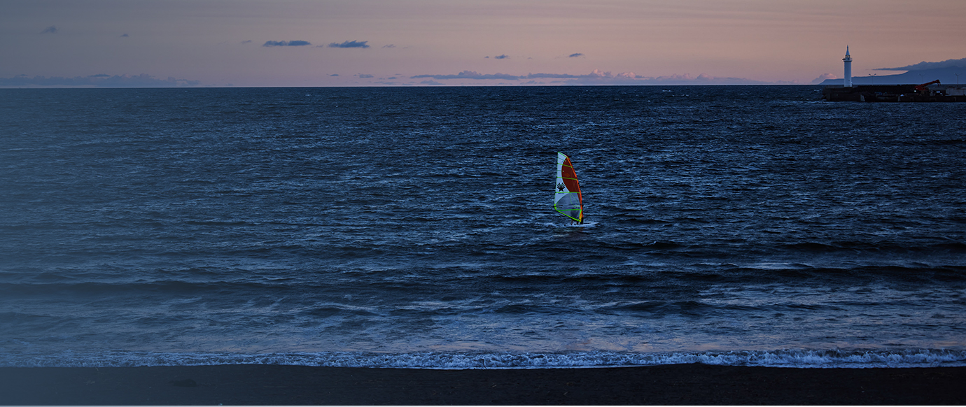 Evening scenery seen from UMITO, showing people doing marine sports at dusk